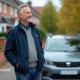 Homme d'âge moyen près d'une minivan en quartier résidentiel
