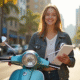 Jeune femme souriante avec scooter 125cc en ville